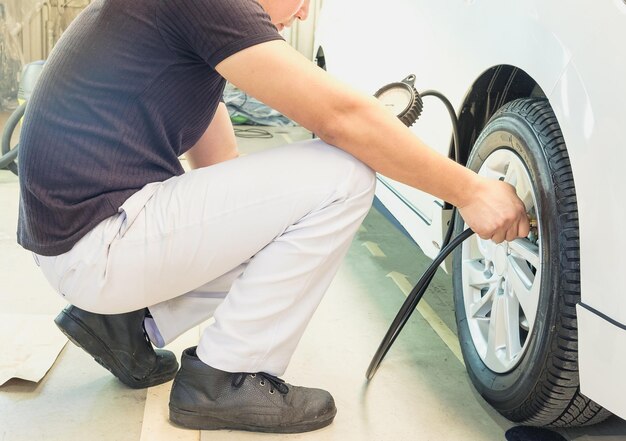 写真 自動車のタイヤに燃料を補給する人の下部