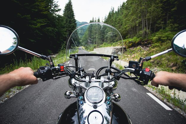 写真 道路でオートバイに乗っている男性の下部