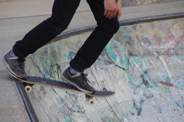 사진 스케이트보드에서 스케이트보드를 타는 남자의 낮은 부분