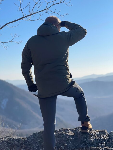 写真 山の上に立っている男の低い部分