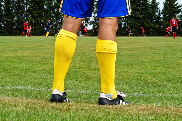 Фото Нижняя часть человека, стоящего на футбольном поле