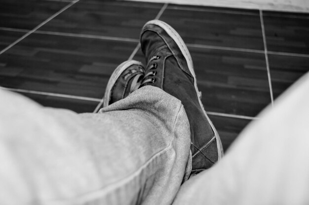 Фото Нижняя часть человека в обуви на плиточном полу