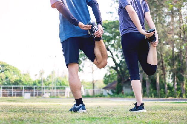 写真 公園で立っている間ストレッチをしている人々の下部