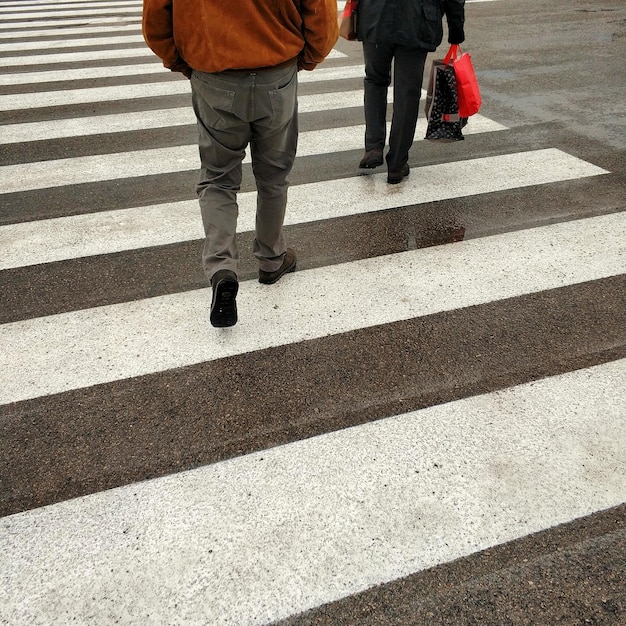 写真 道路でゼブラ・クロッシングをする人々の低層セクション