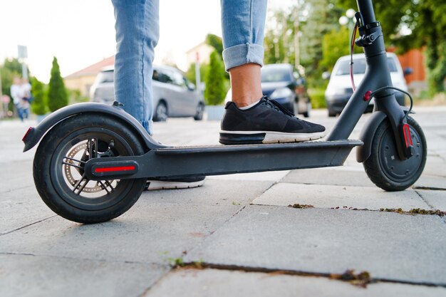 写真 道路でプッシュスクーターに乗っている人の下部