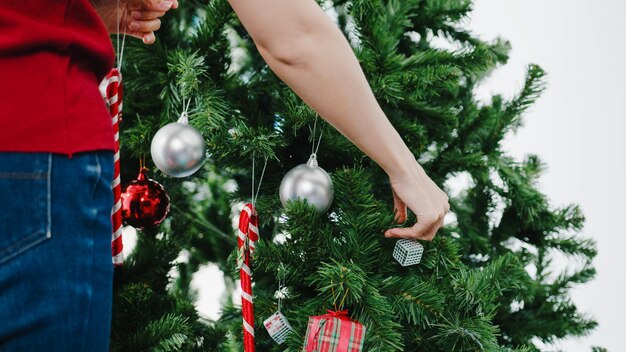 写真 クリスマスツリーを握っている女性の下部