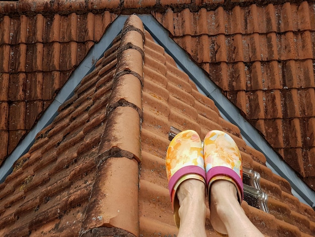 写真 屋根の上にある女性の足の下部