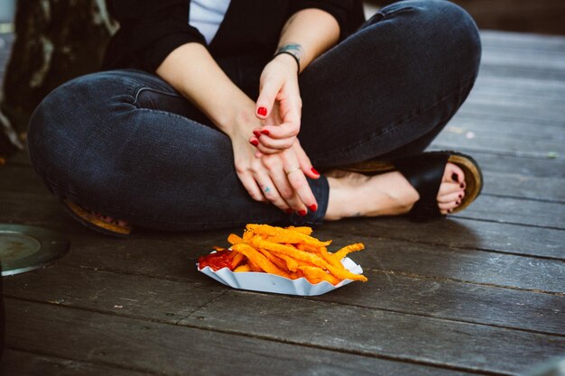 写真 床の上で食べ物のそばに座っている女性の下部