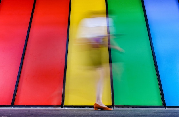 Фото Нижняя часть женщины, идущей по многоцветной стене