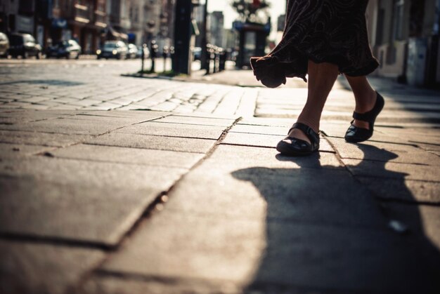 写真 都市の歩道を歩く女性の下部