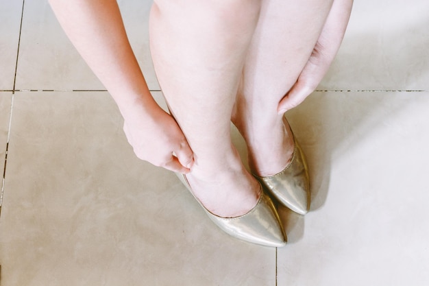 写真 タイル付きの床で靴を履いている女性の下部
