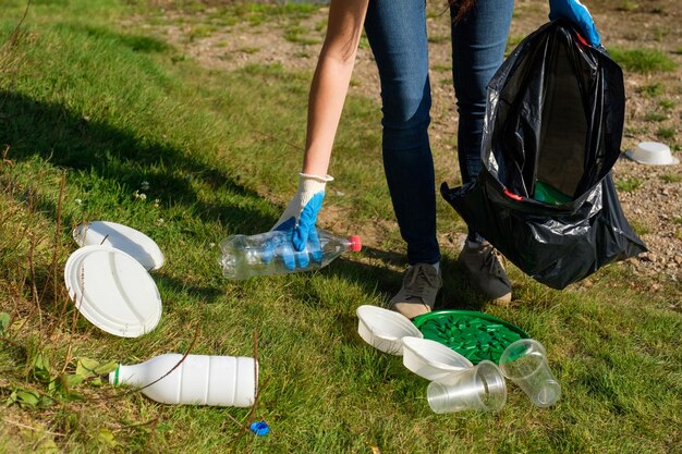 Фото Нижняя часть женщин собирает пластик в мешках