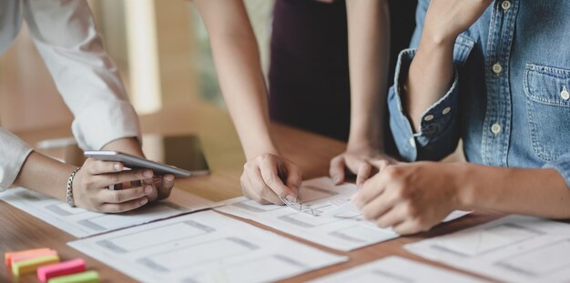 Low section of people holding hands on table