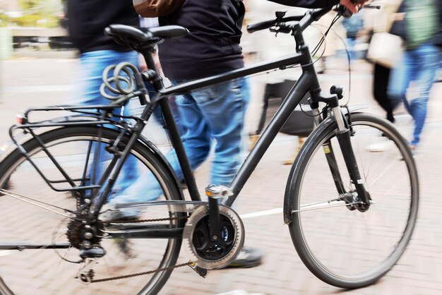 Foto sezione bassa di persone in bicicletta per strada