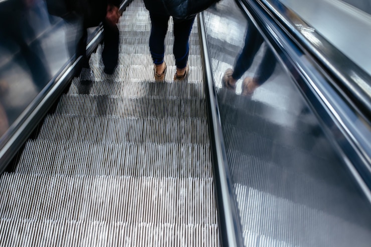 Photo low section of people standing on escalator