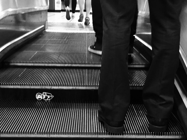 Photo low section of people standing on escalator