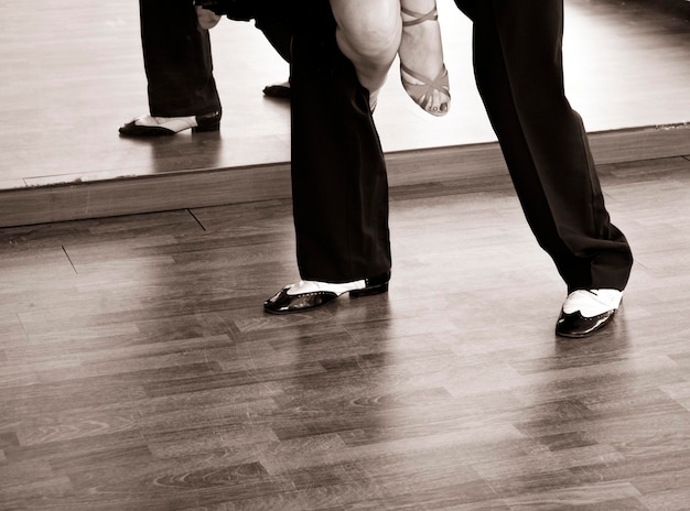 Low section of people standing on hardwood floor