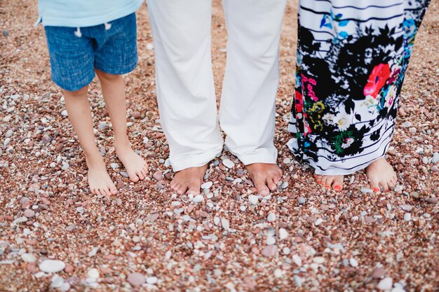 Photo low section of people standing on pebbles