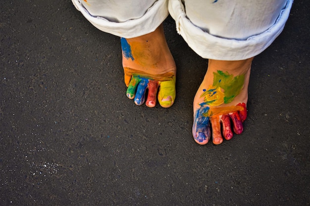 Low section of people standing on road with paint in her skin