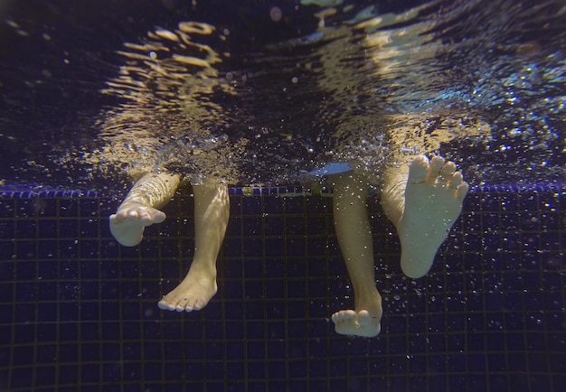 Photo low section of people swimming in pool