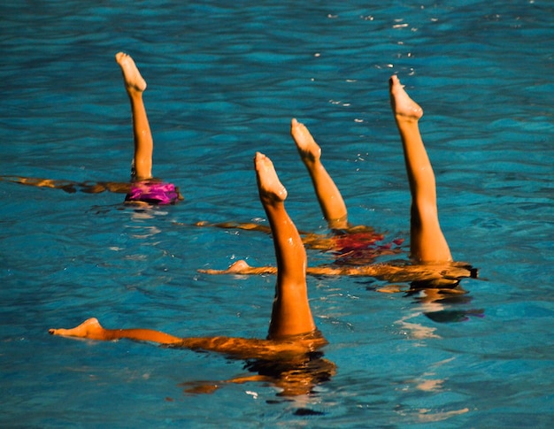 Photo low section of people swimming in pool