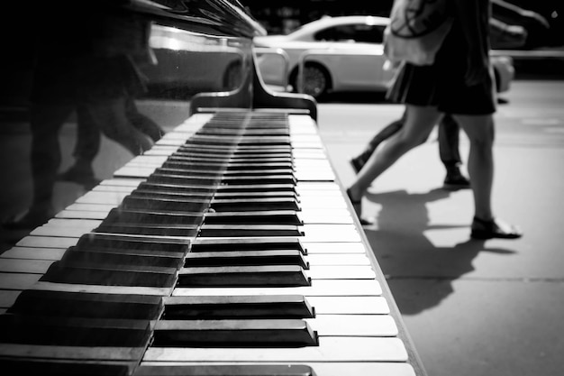 Foto sezione bassa di persone che camminano con il pianoforte a coda sul marciapiede