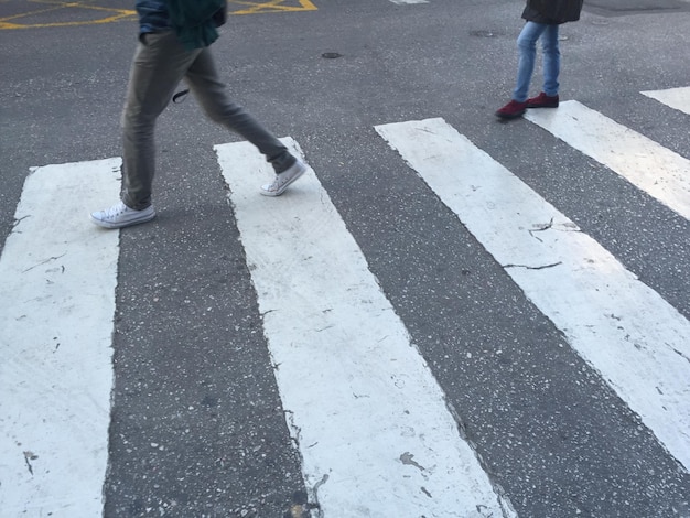 Low section of people walking on city street