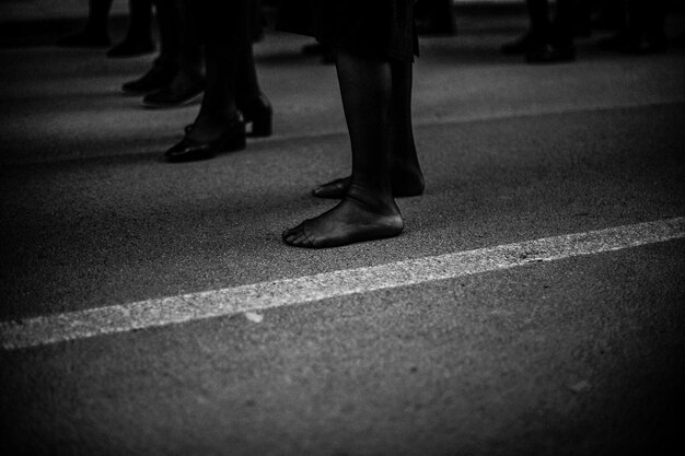 Foto sezione bassa di persone che camminano sulla strada