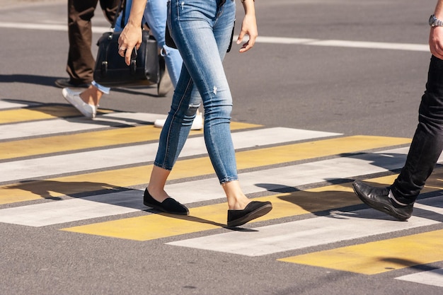 Foto sezione bassa di persone che camminano sulla strada