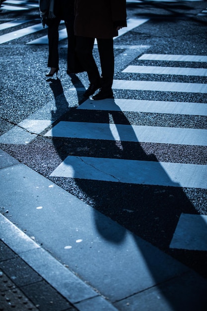 Foto sezione bassa di persone che camminano sulla strada