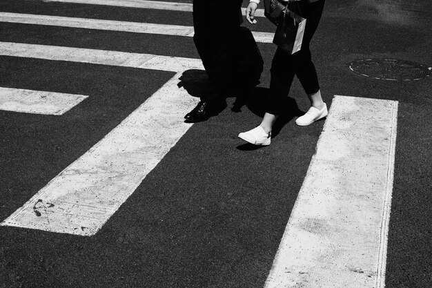 Foto sezione bassa di persone che camminano sulla strada