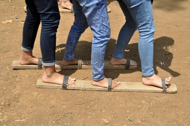 Foto sezione bassa di persone che indossano una tavola di legno mentre sono sul campo