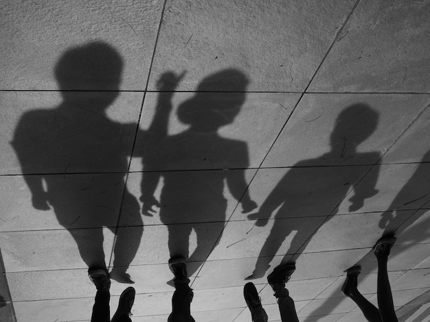 Photo low section of people with shadows walking on road