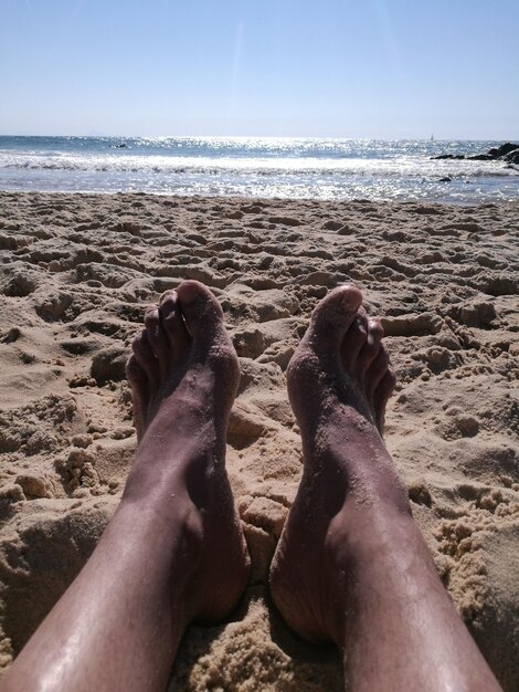 Foto sezione bassa della persona sulla spiaggia