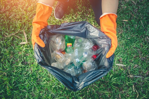 Photo low section of person cleaning garbage on field