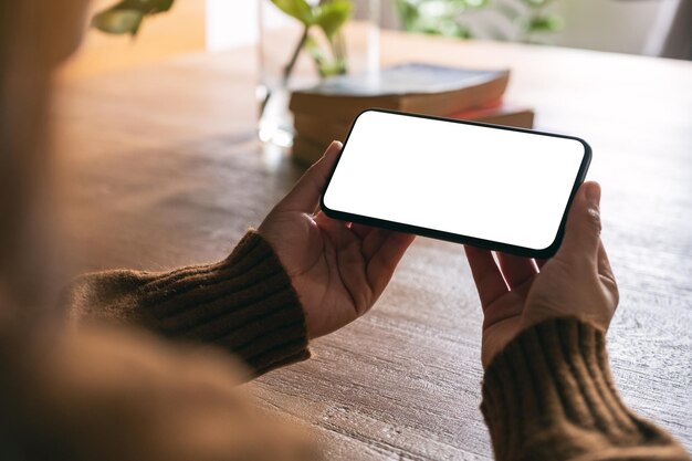 Low section of person holding smart phone on table