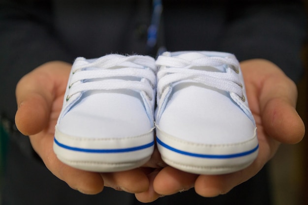 Photo low section of person holding white shoes