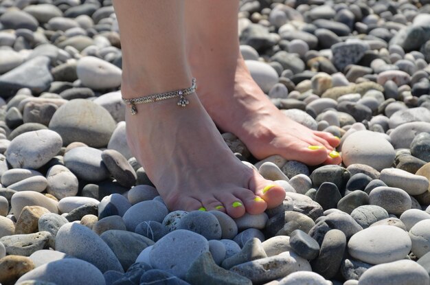 Low section of person on pebbles at beach