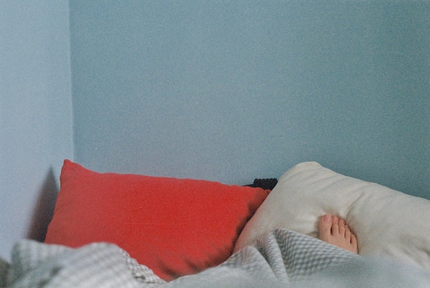 Photo low section of person relaxing on bed against wall