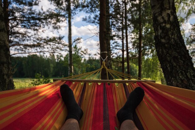 Photo low section of person relaxing on hammock in forest