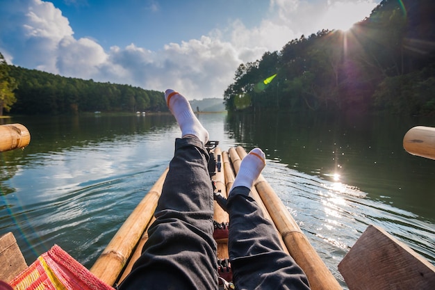 Foto sezione bassa di una persona che si rilassa su una zattera di legno nel lago