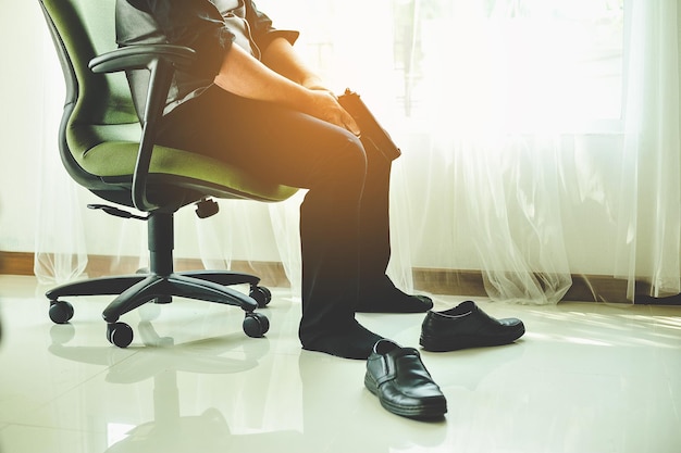 Low section of person sitting on chair at home