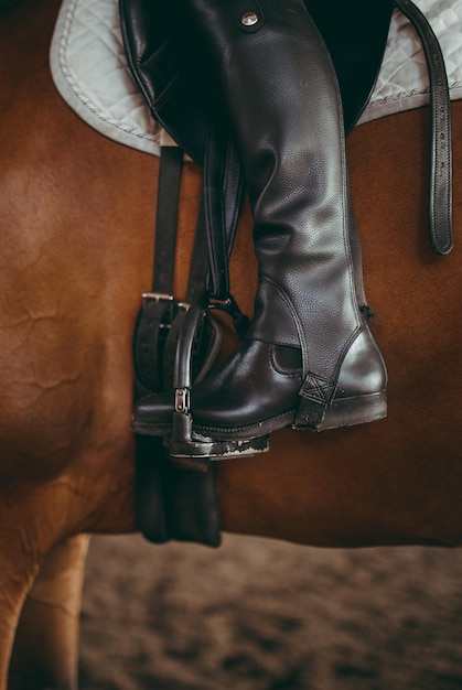 Foto sezione inferiore di una persona seduta su un cavallo