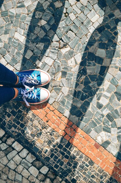 Photo low section of person standing on footpath