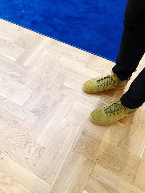 Low section of person standing on hardwood floor