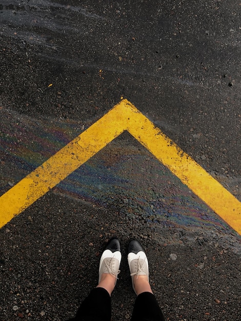 Foto sezione bassa di una persona in piedi sulla strada