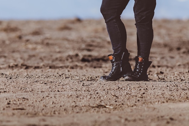 low section of person standing on sand at beach