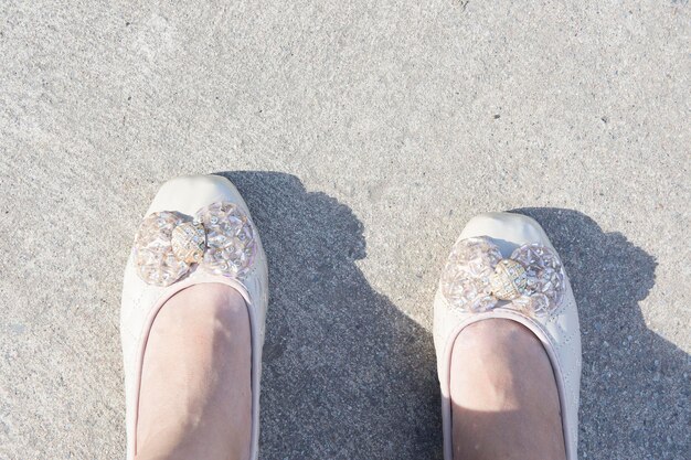 Low section of person standing on sand