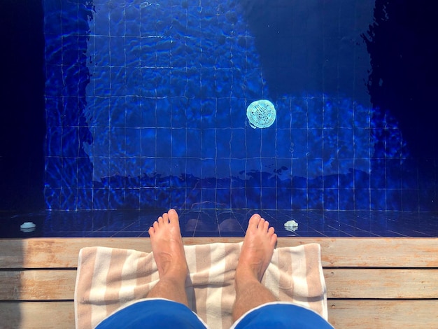 Low section of person standing in swimming pool