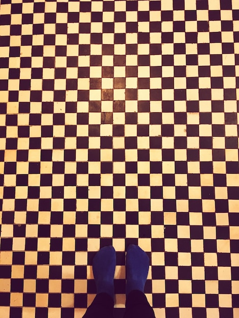 Photo low section of person standing on tiled floor